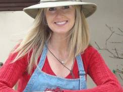 woman holding paint brushes wearing painting apron and hat